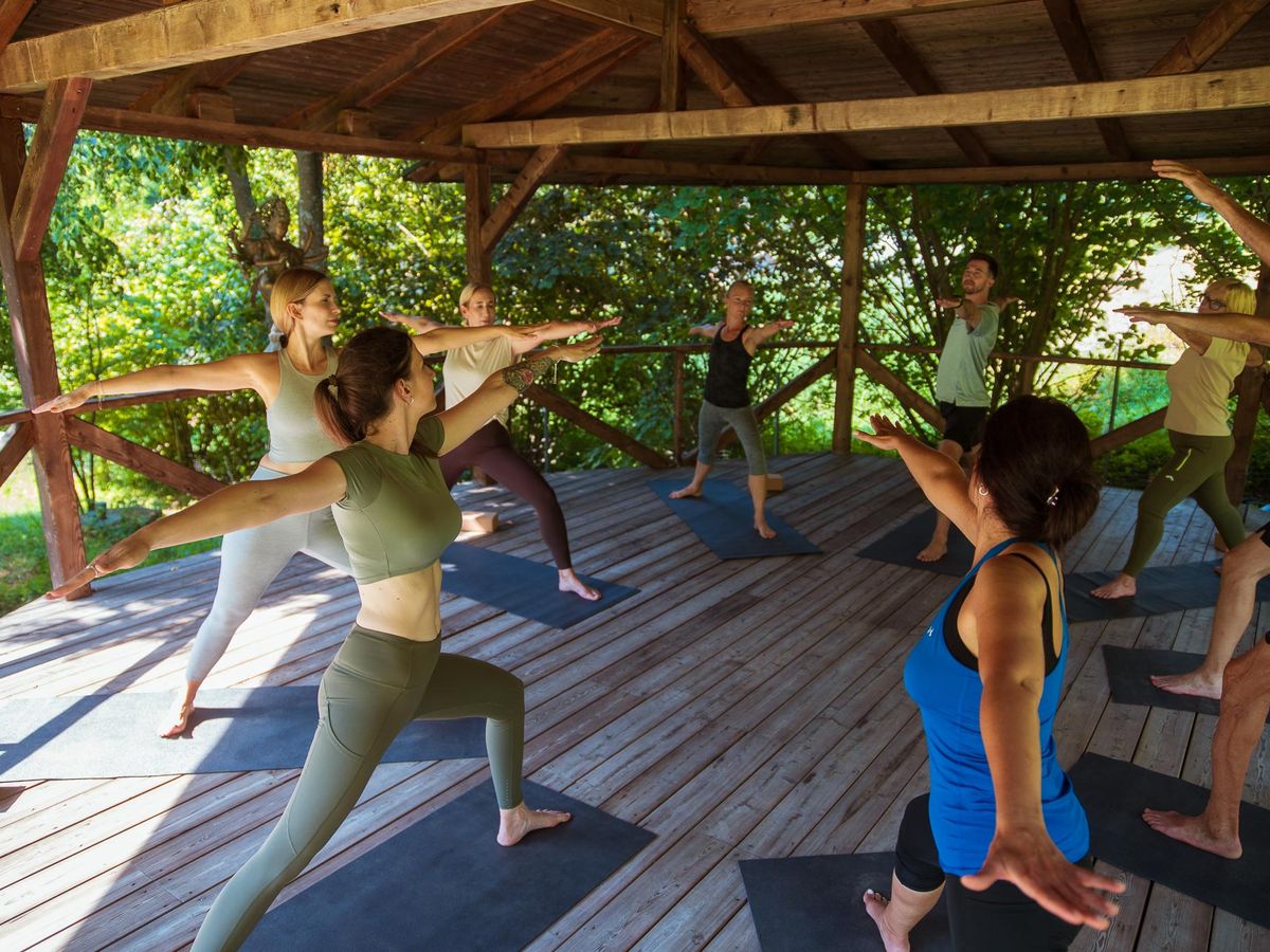 Yogagruppe im Holzpavillon im Grünen