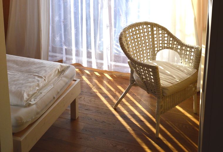Bett am Fenster im Morgenlicht